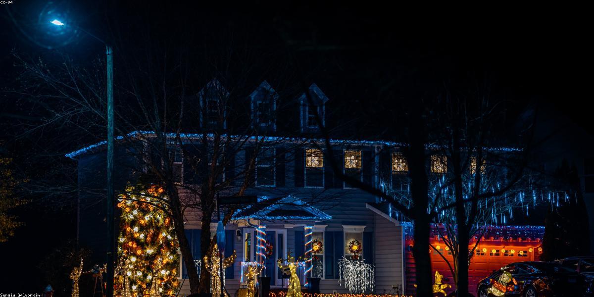 Technician installing holiday lights on roof